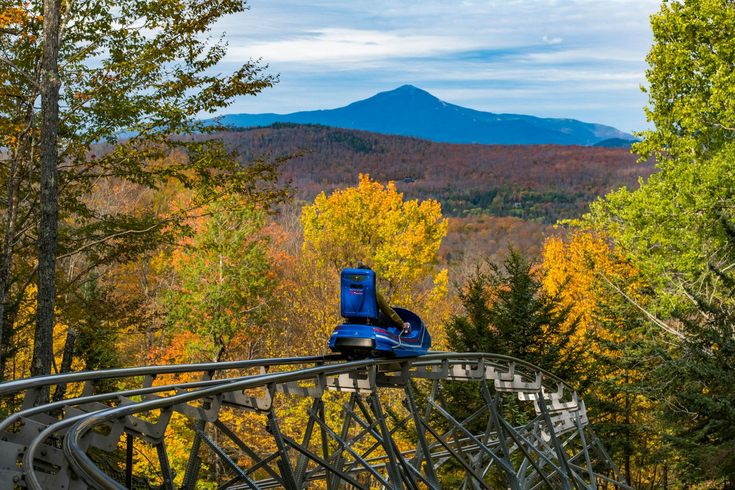 Coast through fall foliage on the longest mountain coaster in the